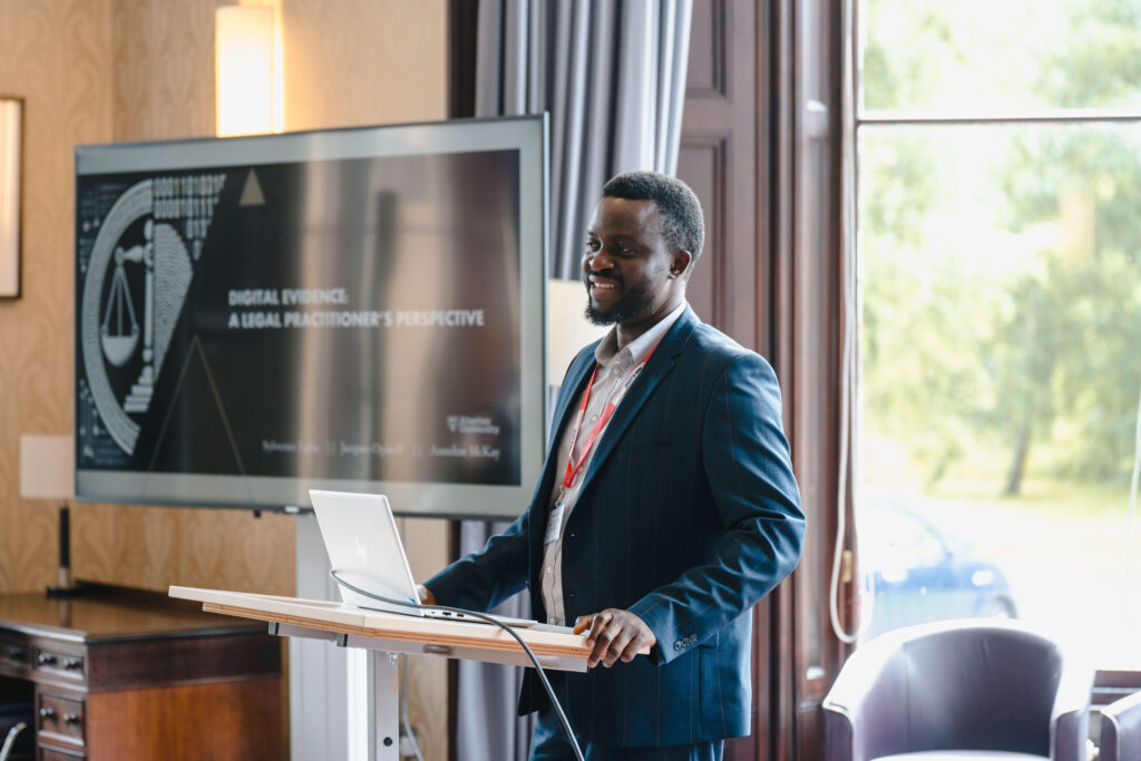 A speaker presenting his research at the lectern